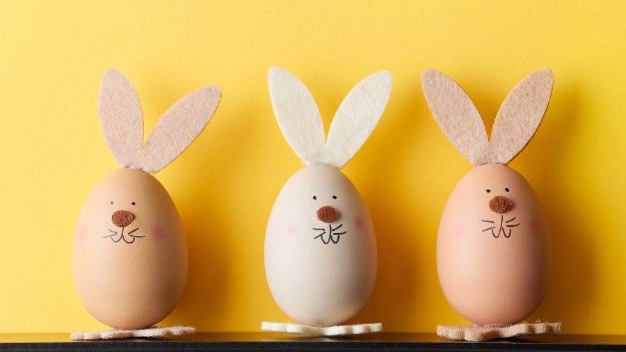 three bunny shaped easter eggs on yellow background